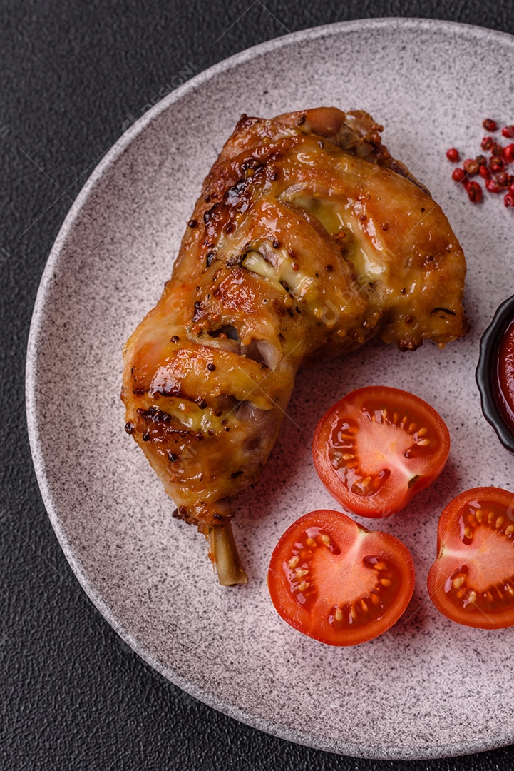 Deliciosa coxa ou quarto de frango grelhado com sal e especiarias em fundo escuro de concreto