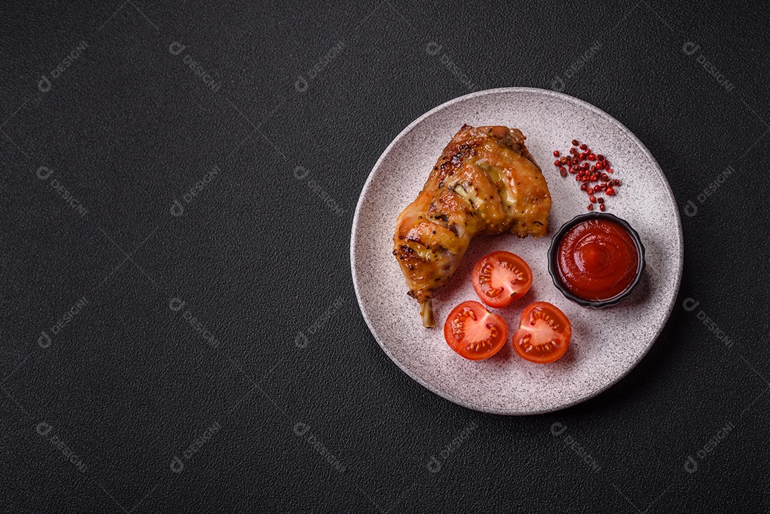 Deliciosa coxa ou quarto de frango grelhado com sal e especiarias em fundo escuro de concreto