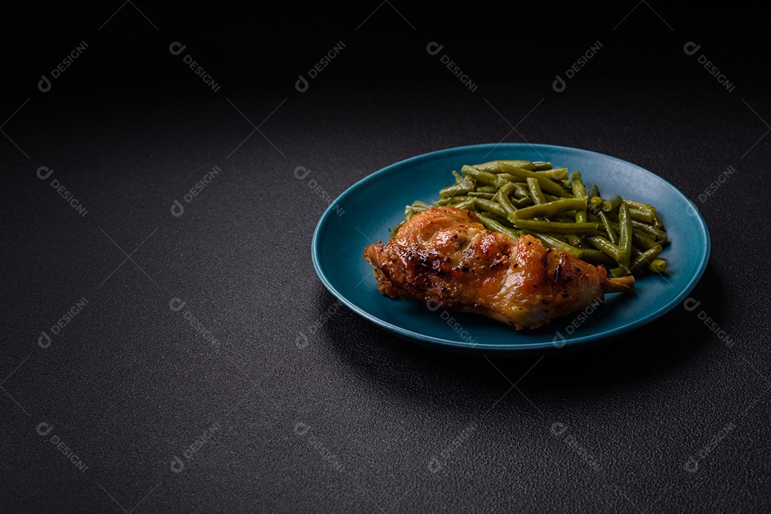 Deliciosa coxa ou quarto de frango grelhado com sal e especiarias em fundo escuro de concreto