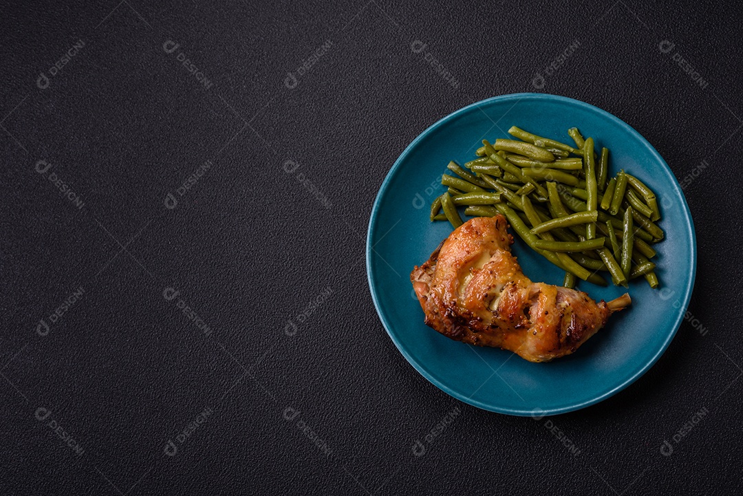 Deliciosa coxa ou quarto de frango grelhado com sal e especiarias em fundo escuro de concreto