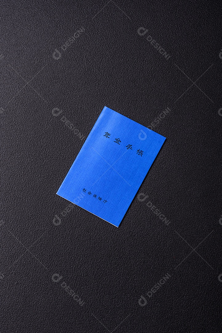 Livro de pensões ou cartão de identificação de cidadão japonês em fundo escuro de concreto