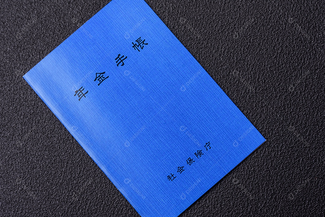 Livro de pensões ou cartão de identificação de cidadão japonês em fundo escuro de concreto