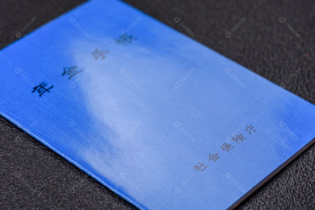 Livro de pensões ou cartão de identificação de cidadão japonês em fundo escuro de concreto