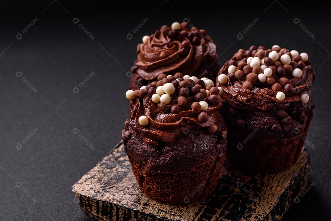 Deliciosos donuts frescos com recheio e cobertura de chocolate sobre um fundo escuro de concreto