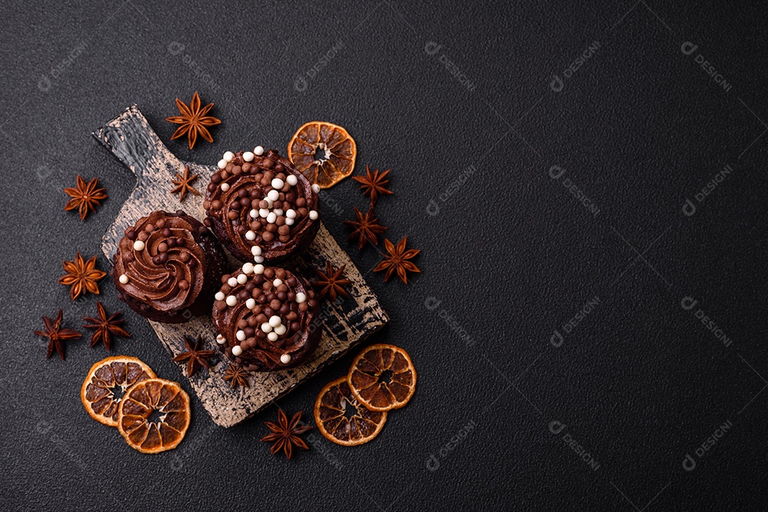 Deliciosos muffins frescos com recheio e cobertura de chocolate sobre um fundo escuro de concreto