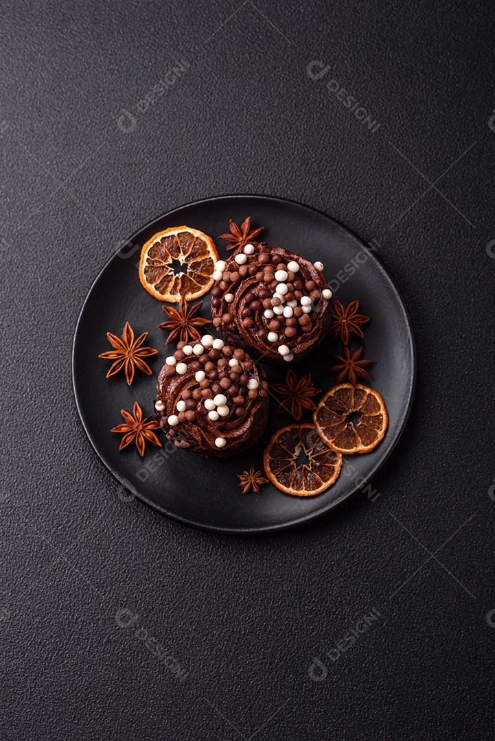 Deliciosos donuts frescos com recheio e cobertura de chocolate sobre um fundo escuro de concreto