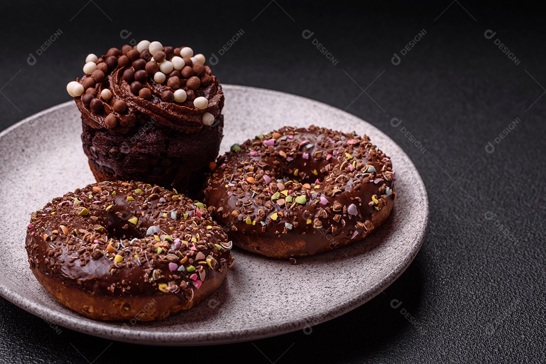 Deliciosos donuts frescos com recheio e cobertura de chocolate sobre um fundo escuro de concreto