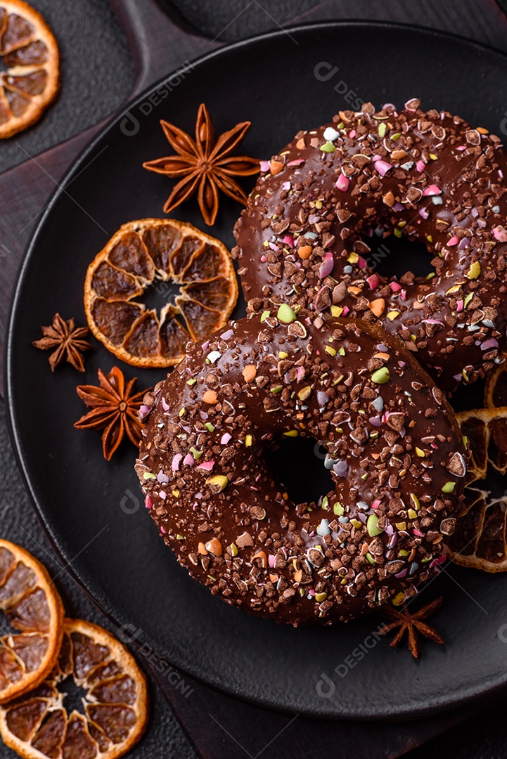 Deliciosos donuts frescos com recheio e cobertura de chocolate sobre um fundo escuro de concret