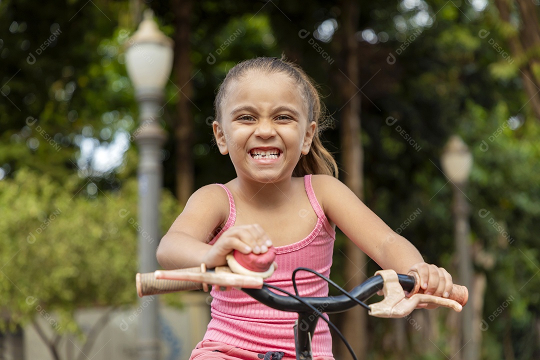 Garotinha alegre na sua bicicleta