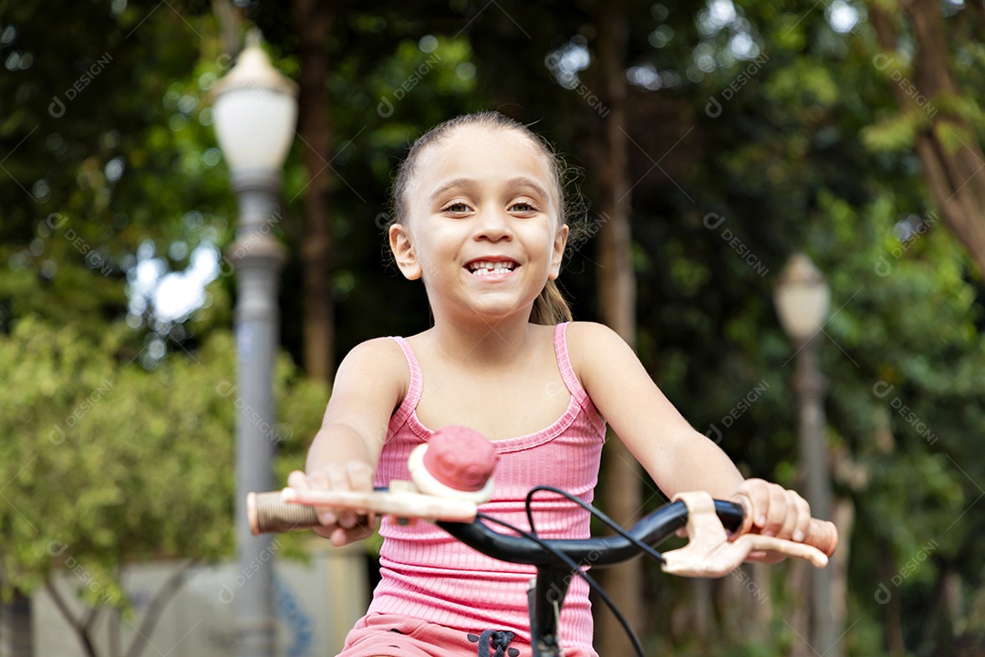 Menina linda e feliz andando de bicicleta