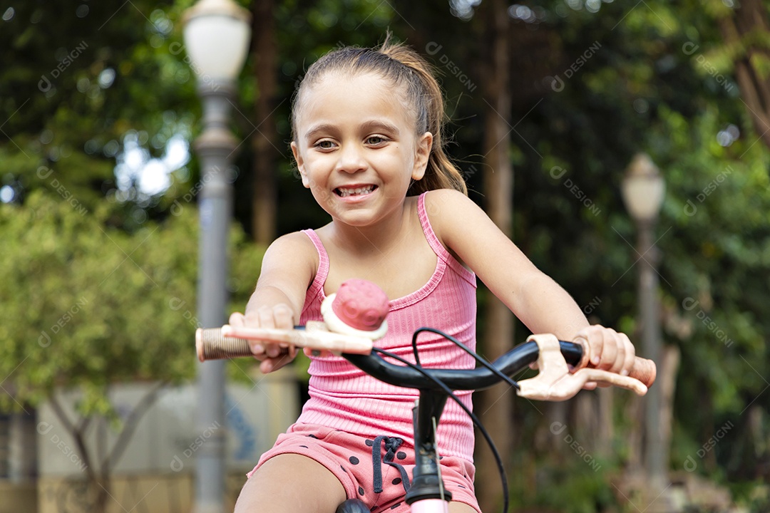 Menina linda e feliz andando de bicicleta