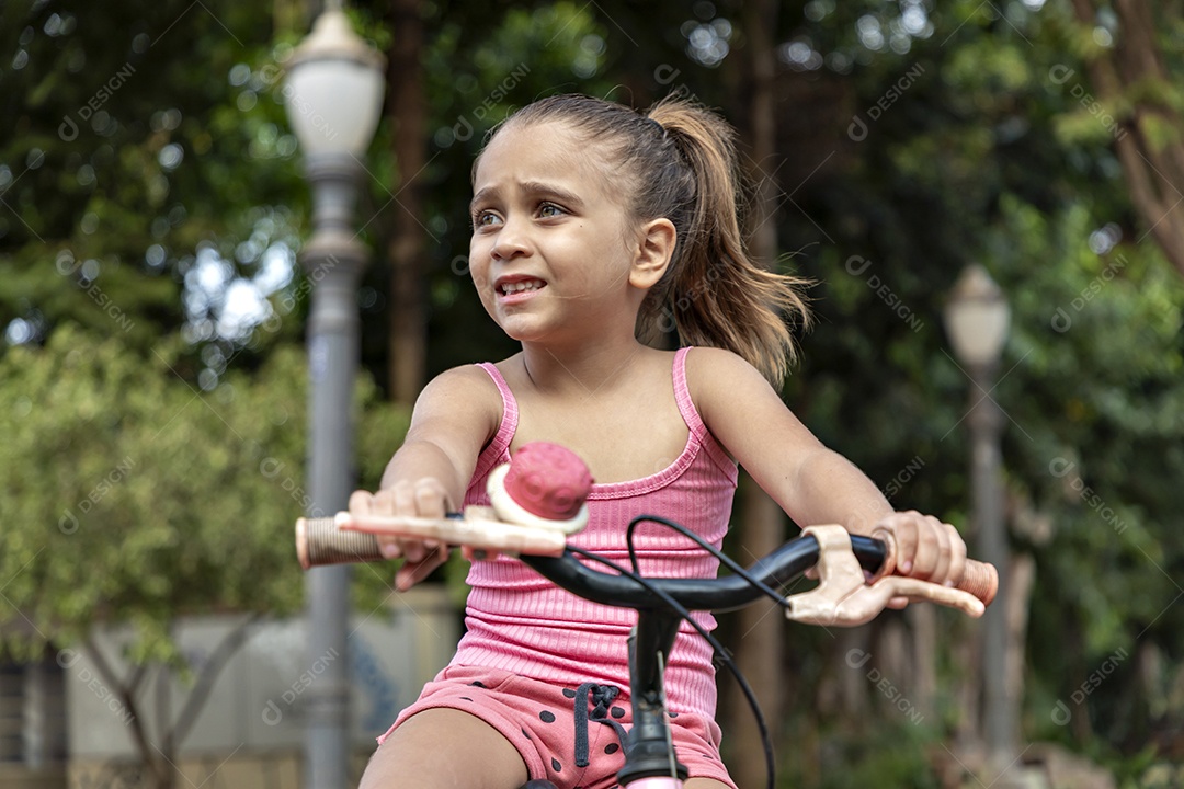 Linda garotinha na sua adorável bicicleta cor de rosa