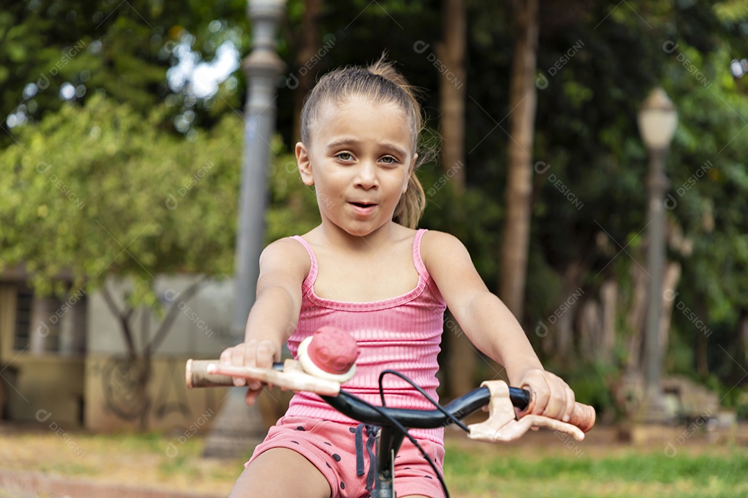 Linda garota na sua bicicleta cor de rosa