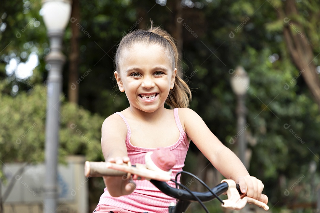 Uma linda garotinha andando de bicicleta feliz