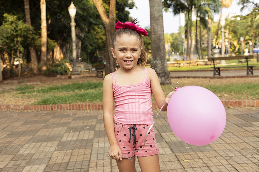 Uma linda menina com balão nas mãos e feliz