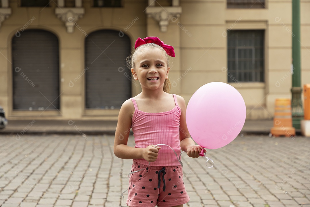 Uma linda menina com balão nas mãos e feliz