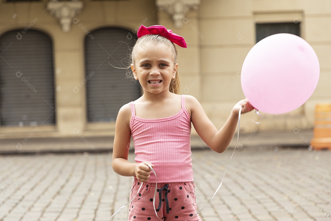 Uma garotinha linda sorrindo com balão nas mãos