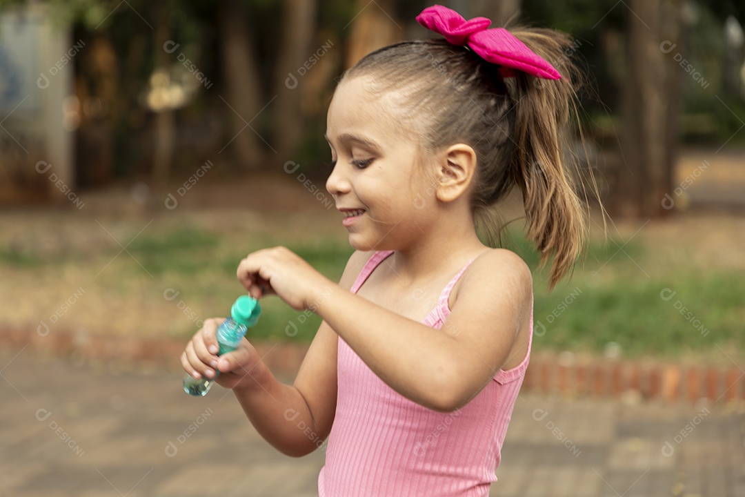 Uma linda garotinha brincando com bolhas de sabão