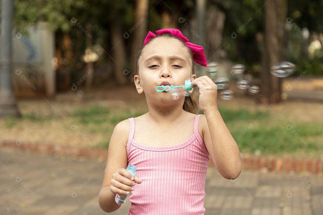 Uma menina adorável brincando com bolhas de sabão
