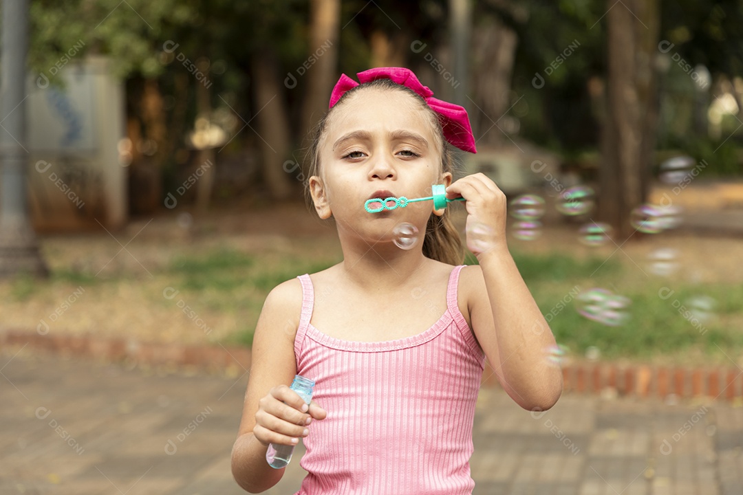 Uma menina adorável brincando com bolhas de sabão