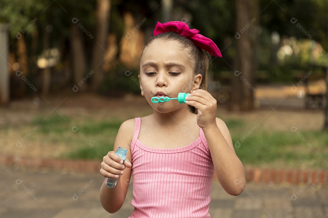 Uma menina adorável brincando com bolhas de sabão