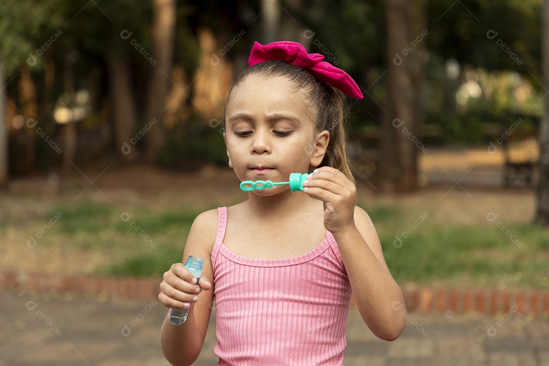 Uma menina adorável brincando com bolhas de sabão