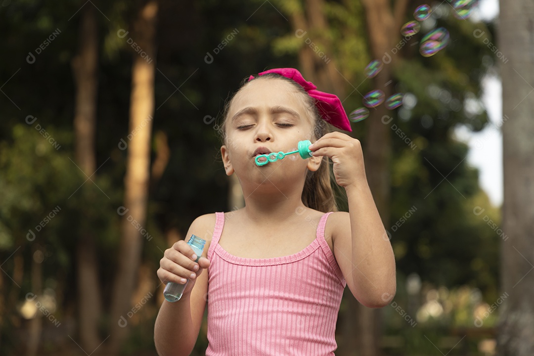 Uma menina adorável brincando com bolhas de sabão
