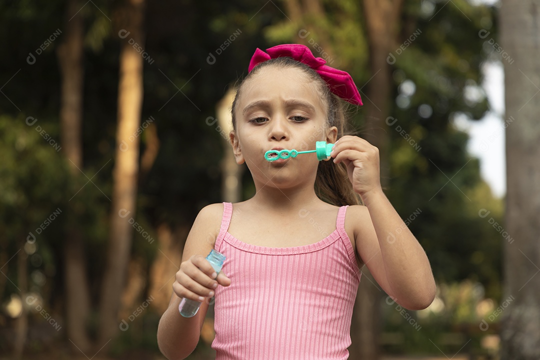 Uma menina adorável brincando com bolhas de sabão