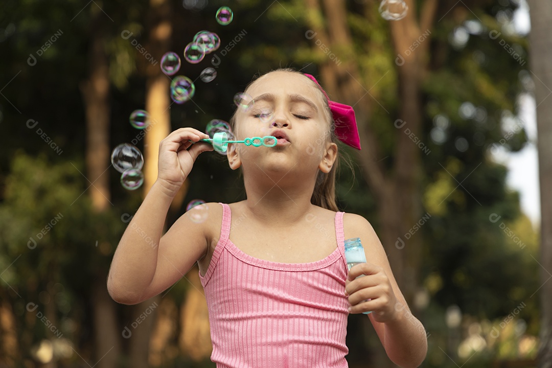 Menina fofa loira brincando com bolhas de sabão