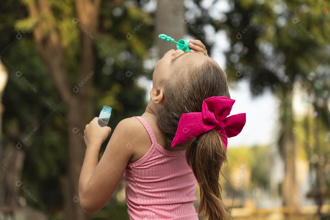 Menina fofa brincando com bolhas de sabão
