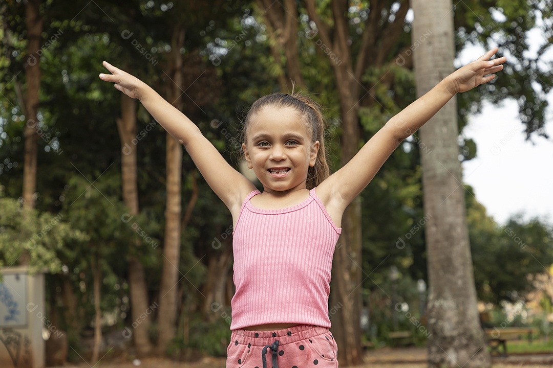 Linda menina loira com braços para cima sorrindo