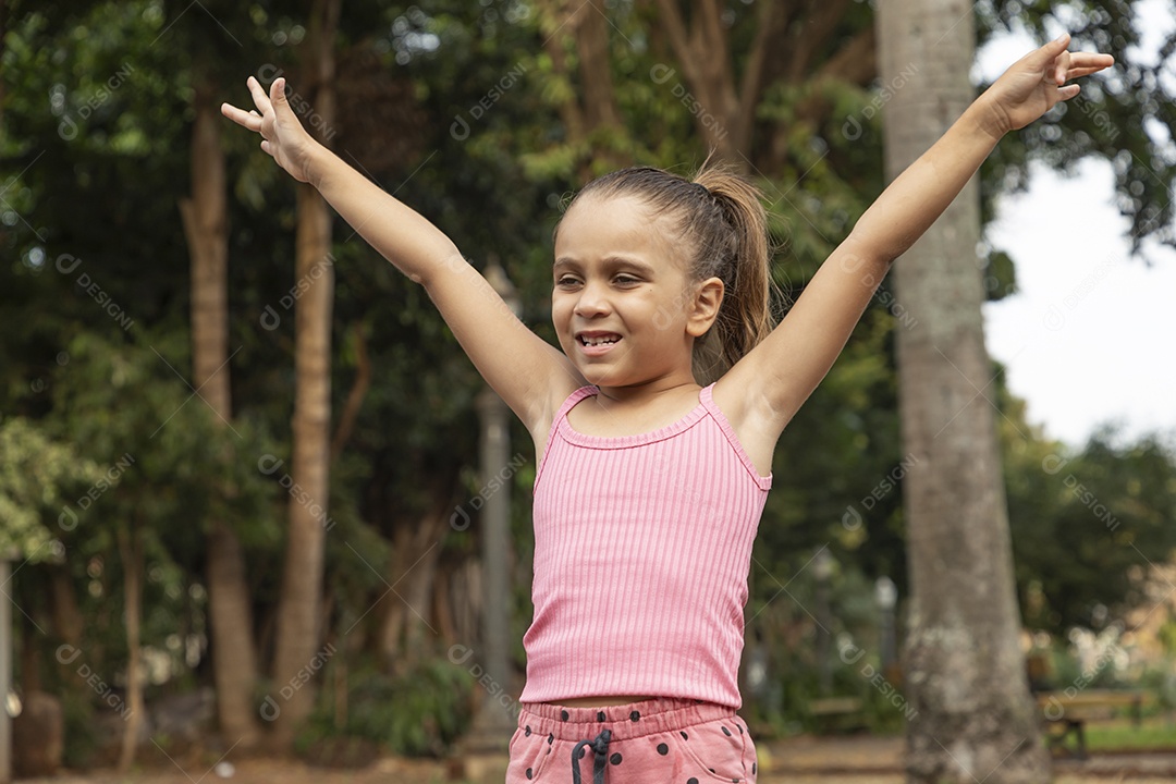 Linda menina loira com braços para cima sorrindo