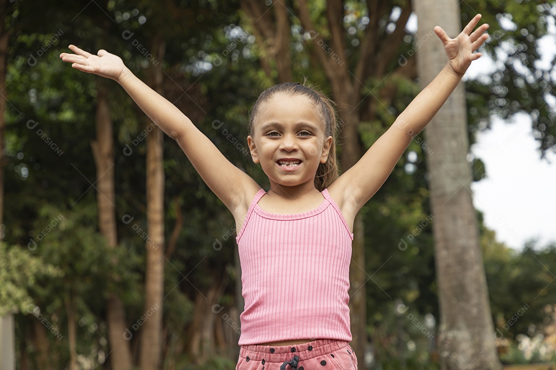 Linda menina loira com braços para cima sorrindo