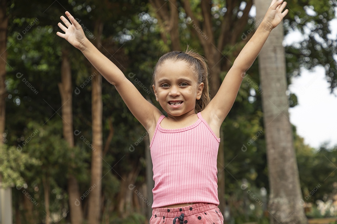 Linda menina loira com braços para cima sorrindo
