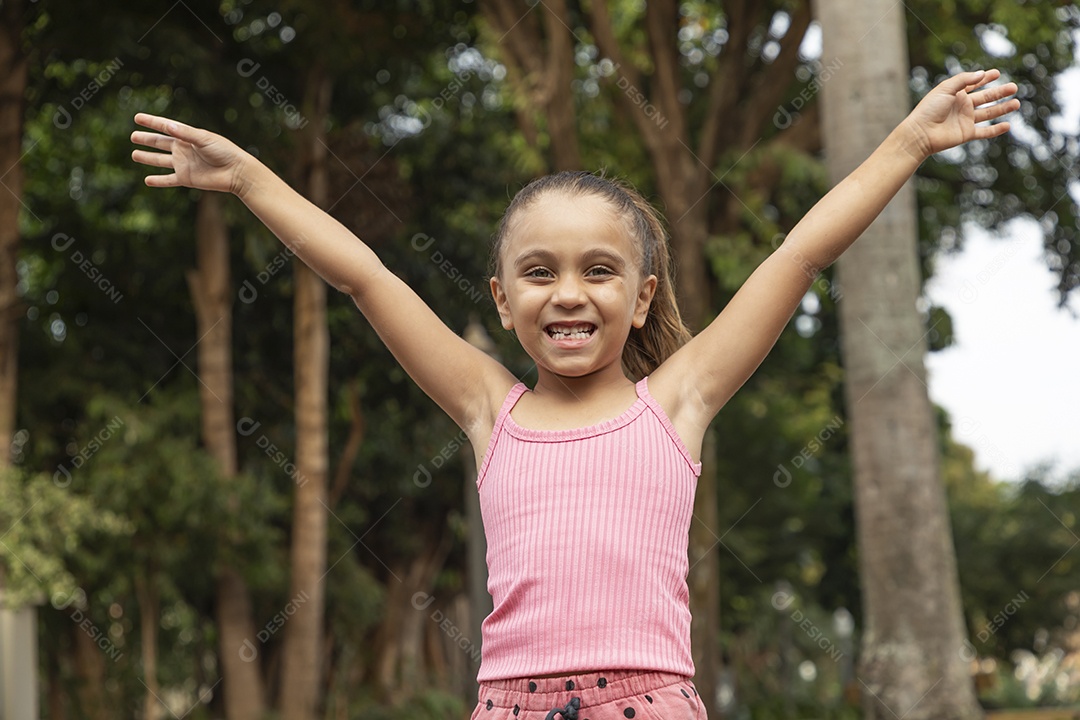 Linda menina loira com braços para cima sorrindo