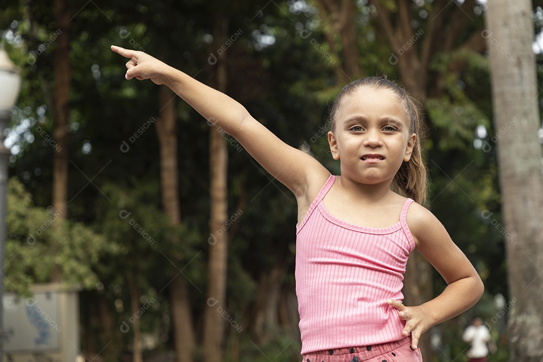 Menina loira feliz apontando para o lado