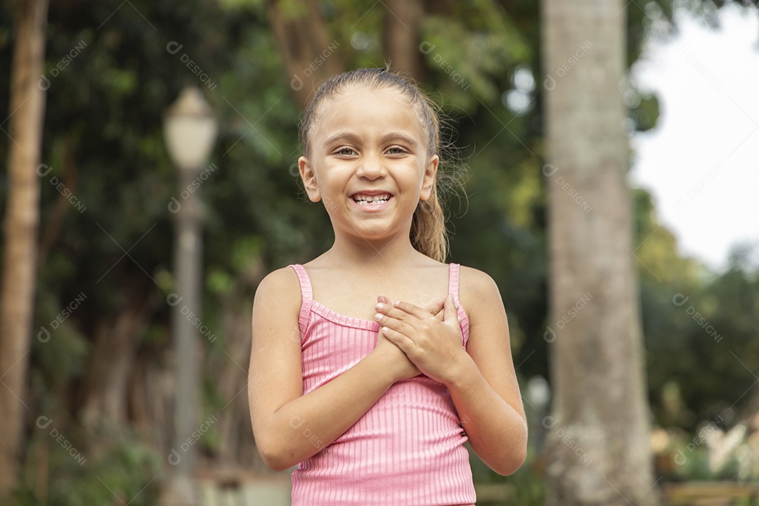 Menina loira linda com mãozinha no peito e sorrindo