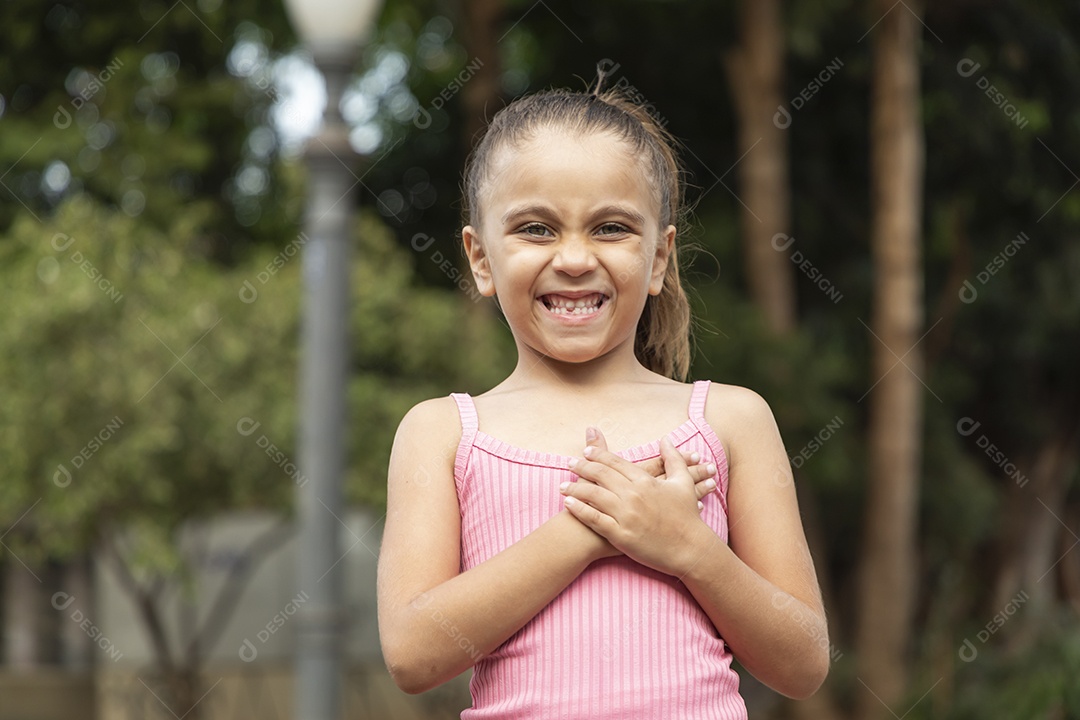 Menina loira linda com mãozinha no peito e sorrindo