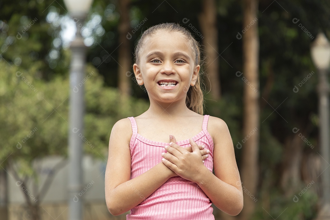 Menina loira linda com mãozinha no peito
