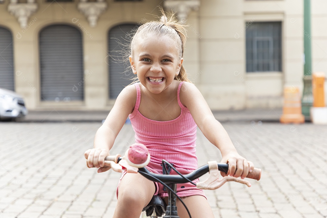 Menina linda e feliz andando de bicicleta