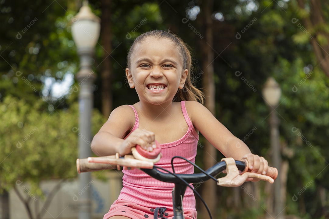 Linda garotinha loira sorrindo na sua bicicleta