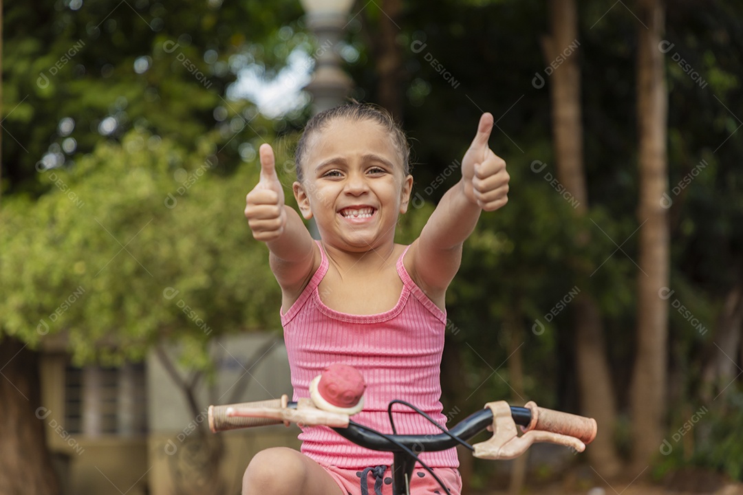 Linda menina feliz andando na sua bicicleta