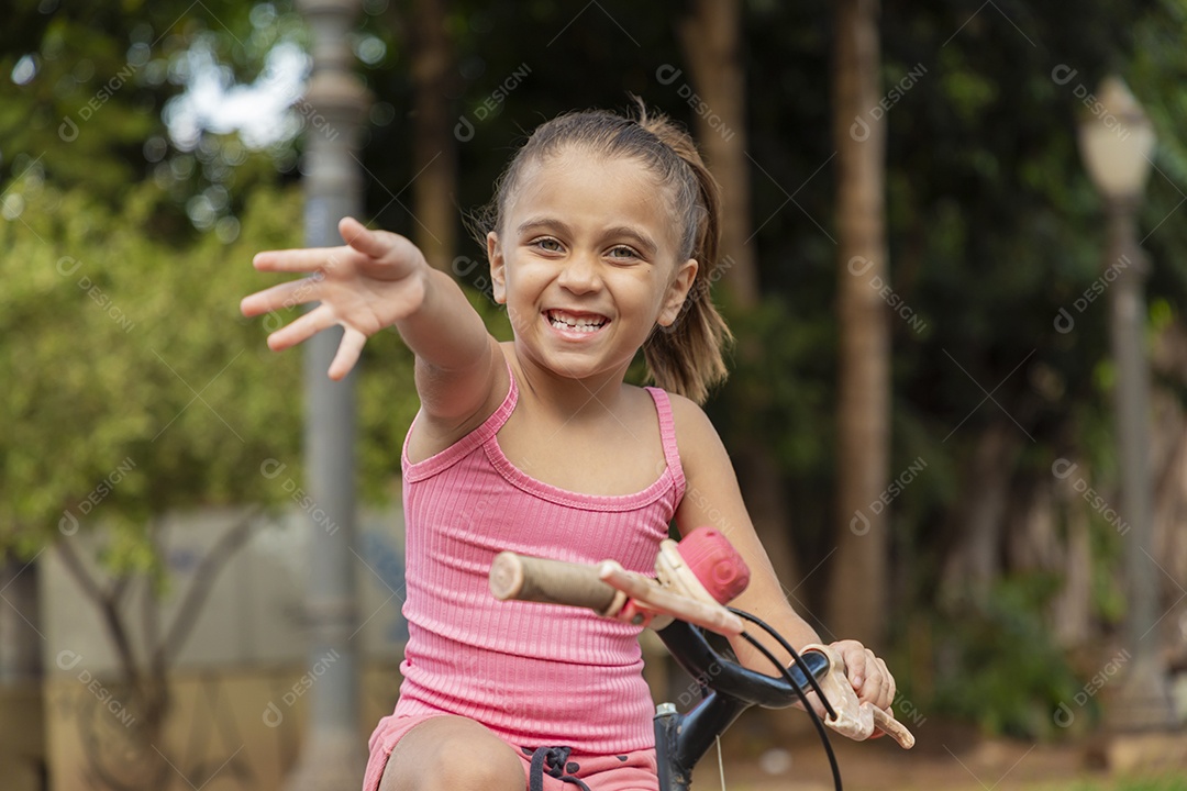 Linda garota feliz andando de bicicleta