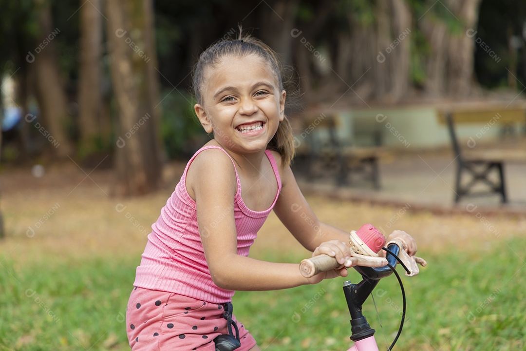 Linda garota feliz andando de bicicleta