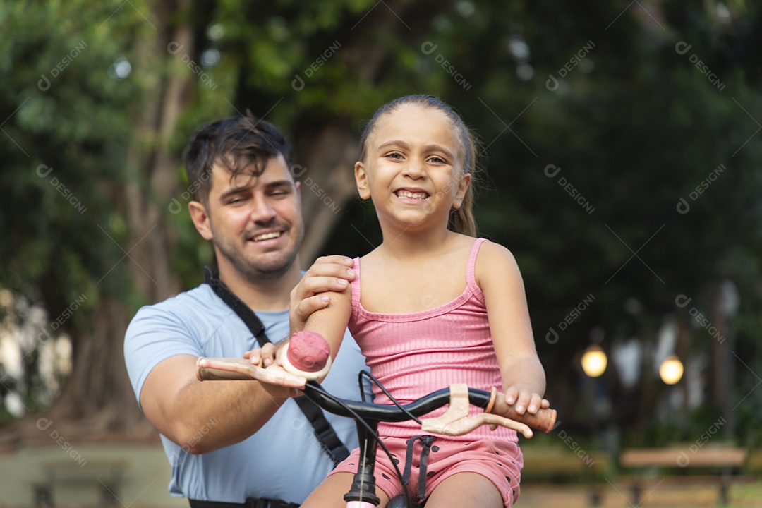 Um pai brincando com sua filha no parque