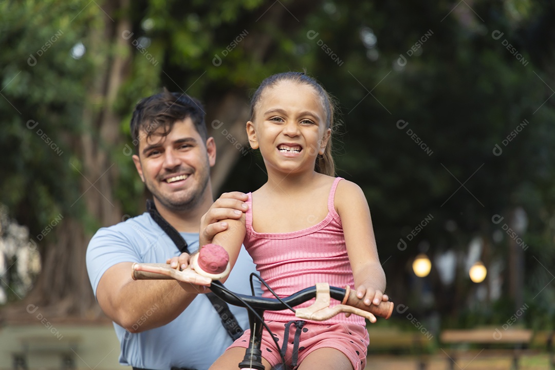 Um pai brincando com sua filha no parque