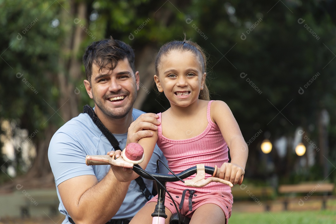 Um pai brincando com sua filha no parque