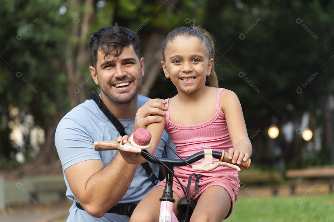 Um pai brincando com sua filha no parque