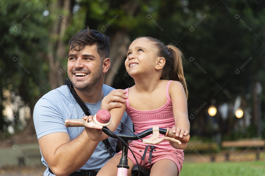 Um pai brincando com sua filha no parque