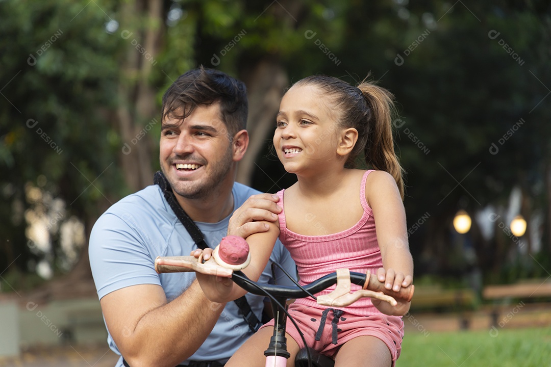 Um pai brincando com sua filha no parque